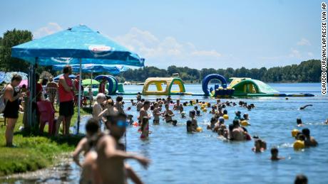 In Italië wordt het weer normaal.  Mensen zwemmen op 12 juli in een kunstmatig meer in Milaan.
