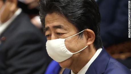 De Japanse premier Shinzo Abe draagt ​​een gezichtsmasker uit bezorgdheid over de verspreiding van het coronavirus, spreekt tijdens een zitting van de begrotingscommissie in het lagerhuis van het parlement in Tokio op 10 juni 2020.