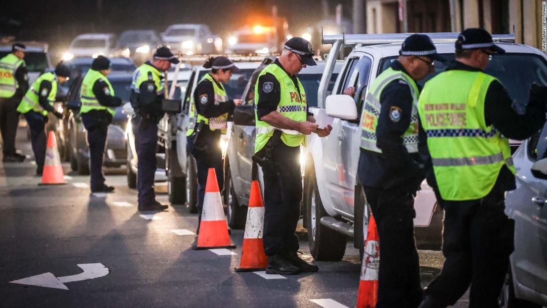 Police in the southern New South Wales (NSW) border city of Albury check cars crossing the state border from Victoria on July 7, 2020 as authorities close the border due to an outbreak of COVID-19 coronavirus in Victoria. - Australia on July 7 ordered millions of people locked down in its second-biggest city to combat a surge in coronavirus cases, as nations across the planet scrambled to stop the rampaging pandemic. (Photo by William WEST / AFP) (Photo by WILLIAM WEST/AFP via Getty Images)
