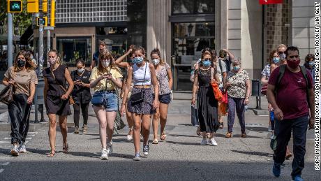 Mensen dragen gezichtsmaskers in Barcelona, ​​Spanje, waar degenen die dat niet doen in de openbare ruimte een boete van 100 euro krijgen.
