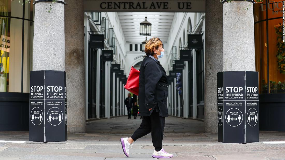 A pedestrian wearing a protective face mask passes an entrance to Covent Garden Market in London on Saturday, July 4. It is not mandatory to wear a mask in public places in England.