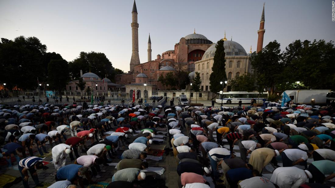 Muslims offer their evening prayers outside the Byzantine-era Hagia Sophia, one of Istanbul's main tourist attractions in the historic Sultanahmet district of Istanbul, following Turkey's Council of State's decision, Friday, July 10, 2020. Turkey's highest administrative court issued a ruling Friday that paves the way for the government to convert Hagia Sophia - a former cathedral-turned-mosque that now serves as a museum - back into a Muslim house of worship. The Council of State threw its weight behind a petition brought by a religious group and annulled a 1934 cabinet decision that changed the 6th century building into a museum. (AP Photo/Emrah Gurel)