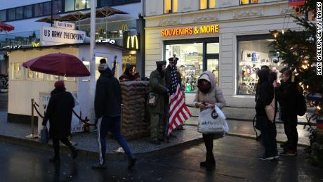 Toeristen maken foto's van acteurs verkleed als soldaten bij voormalig Checkpoint Charlie in Berlijn, waar Amerikaanse en Sovjet-tanks elkaar in de eerste jaren van de Koude Oorlog confronteerden.