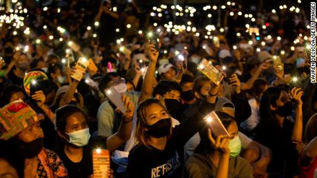 Studenten en demonstranten tegen de regering steken hun telefoon op bij het Democracy Monument op 16 augustus 2020 in Bangkok.